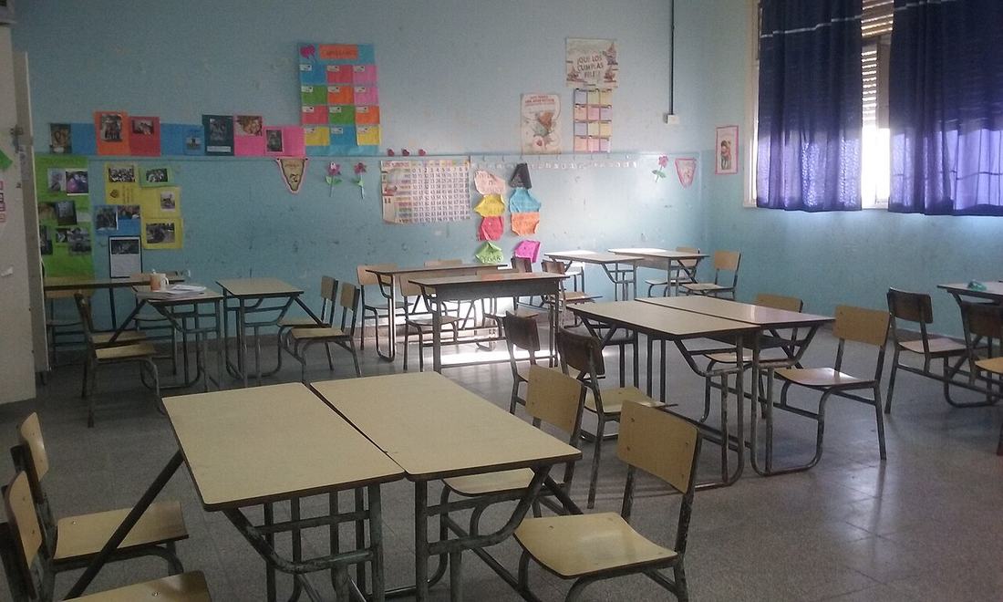 An empty classroom with desks and chairs